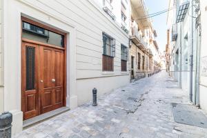 un callejón vacío con una puerta de madera en un edificio en Céntrico y tranquilo apartamento Realejo, en Granada
