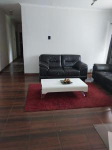 a living room with a black couch and a white coffee table at Vaal holiday home in Vanderbijlpark