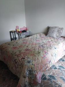 a bedroom with a bed with a floral comforter at Vaal holiday home in Vanderbijlpark
