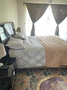 a bedroom with a large bed and a window at Vaal holiday home in Vanderbijlpark