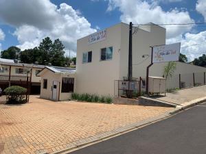 パト・ブランコにあるHOTEL POUSADA POR DO SOLの通り沿いにある白い建物