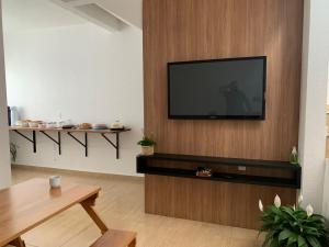 a living room with a flat screen tv on a wall at HOTEL POUSADA POR DO SOL in Pato Branco