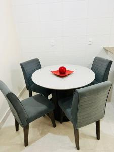 una mesa con cuatro sillas y una servilleta roja. en Apartamento lugar de Paz, en Salvador