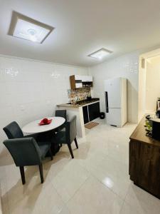 a kitchen with a table and chairs and a refrigerator at Apartamento lugar de Paz in Salvador