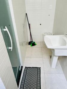 a bathroom with a toilet and a sink and a mop at Apartamento lugar de Paz in Salvador