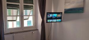 a flat screen tv on a wall next to a window at Genova Rooms Brignole B in Genoa