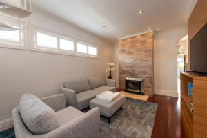 sala de estar con sofá y chimenea en Renovated 3 Bedroom Family Home in Richmond with Parking, en Melbourne