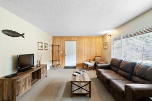 sala de estar con sofá y TV en Indian Creek Lodge, en Douglas City