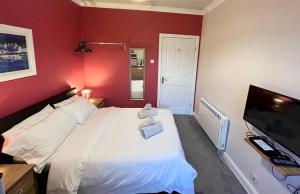 a bedroom with a white bed and a flat screen tv at The waterfront in Tarbert