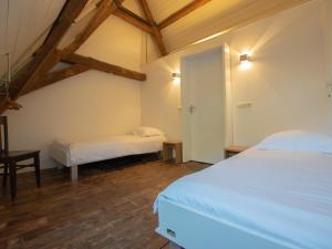 1 dormitorio con 2 camas en una habitación con techos de madera en De Jager en de gelagkamers, en Gouwelaar