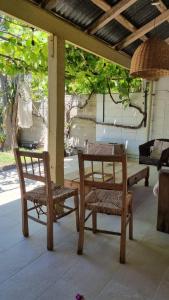 une terrasse couverte avec un banc, une table et une chaise dans l'établissement Departamento de huéspedes con piscina y parrilla, Tranquilo y Céntrico, à Colonia del Sacramento