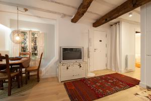 ein Wohnzimmer mit einem TV und einem Esszimmer in der Unterkunft Aittitta Makurra etxea in Lekeitio