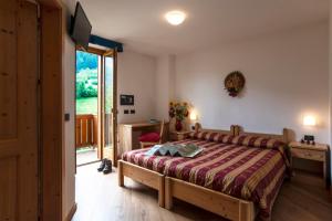 Postel nebo postele na pokoji v ubytování Hotel Chalet Genziana