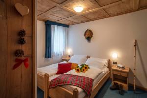 A bed or beds in a room at Hotel Chalet Genziana