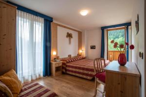 Postel nebo postele na pokoji v ubytování Hotel Chalet Genziana