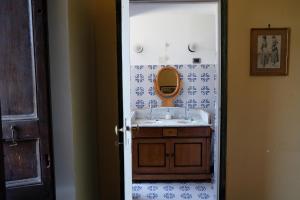 y baño con lavabo y espejo. en Relais Villa Giusso, en Vico Equense