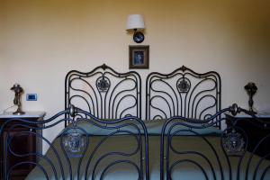 ヴィーコ・エクエンセにあるRelais Villa Giussoのベッドルーム1室(ベッド2台、壁掛け時計付)