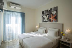 Un dormitorio con una gran cama blanca y una ventana en Telesilla Hotel, en Kontokali