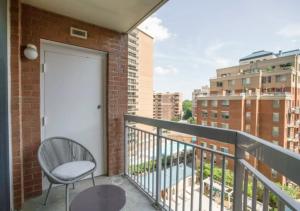 uma varanda com uma porta branca e uma cadeira em Fantastic 1BD Condo At Ballston With Gym em Arlington