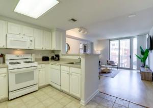 a kitchen with white cabinets and white appliances at Fantastic 1BD Condo At Ballston With Gym in Arlington