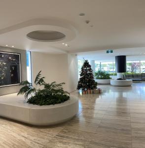 a christmas tree in a lobby with a christmas tree in it at The Fawkner Apartment Bay-view pool/Gym Free Parking in Melbourne