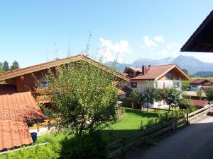 une maison avec une cour et un arbre en face de celle-ci dans l'établissement Akelei, à Obermaiselstein
