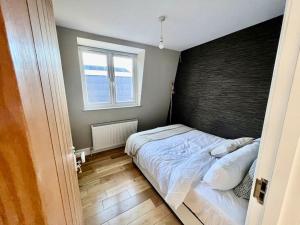 a bedroom with a bed with a black headboard at Lovely two bed flat in London