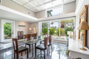 Un comedor con una mesa de cristal y sillas. en Casa Flamingo Intracoastal Front with Heated Pool a and 75 ft Dock, en Fort Lauderdale