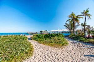 une plage de sable avec des palmiers et un bâtiment dans l'établissement Barrys by the Sea Steps to the Ocean, à Fort Lauderdale