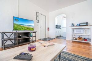 a living room with a tv and a table at Barrys by the Sea Steps to the Ocean in Fort Lauderdale