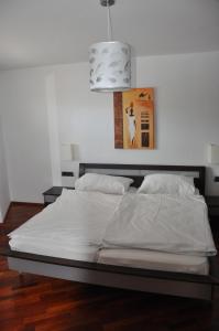 ツェル・アム・ゼーにあるChalet CityXPress Zell am Seeのベッドルーム(白い大型ベッド、ペンダント付)