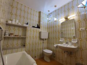 La salle de bains est pourvue d'un lavabo et de toilettes. dans l'établissement Gemütliches Studio mit Garagenparkplatz, à Vols am Schlern