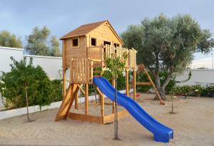 a wooden playground with a slide and a house at Casa Las Olivas in Toledo