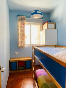 アルメリアにあるCasa Almaの青い壁のベッドルーム1室、ベッド1台、窓が備わります。