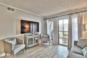 een woonkamer met een tv en een bank en stoelen bij Beach &nightlife 3BR/2.5 BA service dog friendly in Myrtle Beach