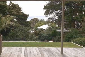 un ombrellone aperto su un patio con cortile di TreeTops ad Auckland