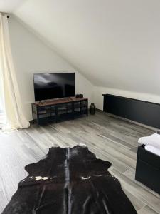 ein Wohnzimmer mit einem Flachbild-TV und einem Sofa in der Unterkunft Haus Gabor in Mülheim an der Ruhr