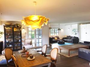 a living room with a table and a yellow chandelier at Getxo Garden Houses - Grand Chalet in Getxo