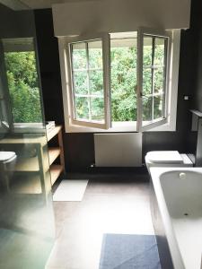 ein Badezimmer mit zwei Fenstern, einem Waschbecken und einem WC in der Unterkunft Getxo Garden Houses - Grand Chalet in Getxo