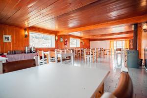 comedor con mesas y sillas y techos de madera en Copahue Hotel en Copahue