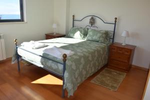 a bedroom with a bed and a wooden floor at Vila Oceânica 2 in Buarcos