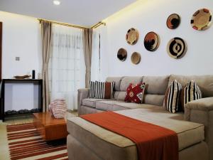 a living room with a couch and a tv at Zendo Suite in Nairobi