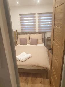 een slaapkamer met een bed met twee handdoeken erop bij Chata Beruška in Kytlice