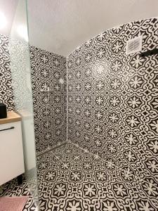 a bathroom with a black and white patterned wall at DMR Apartments in Košice