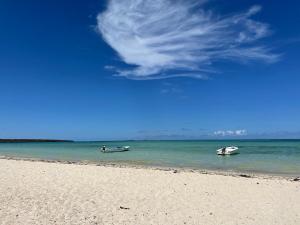 two boats in the water on a beach at Chez Henri in Pointe d'Esny