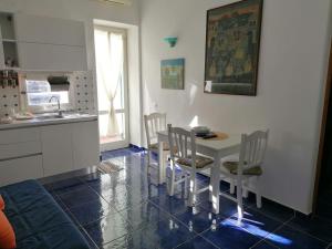 - une cuisine et une salle à manger avec une table et des chaises dans l'établissement Grazioso appartamento a Ischia zona pilastri, à Ischia