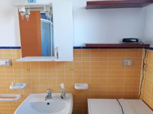 uma casa de banho com um lavatório e um WC em Grazioso appartamento a Ischia zona pilastri em Ischia