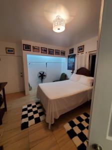 una camera con un grande letto con un pavimento a scacchi di Centrally Located Room - 5 a Port Antonio