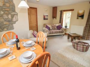 a living room with a wooden table and chairs at 2 Yr Hen Felin in Haverfordwest