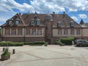 duży budynek z samochodem zaparkowanym przed nim w obiekcie La maison d'Amélie w mieście Birkenwald
